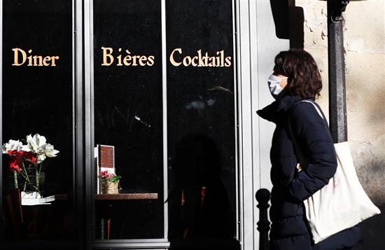 11月18日，一名女子走过法国巴黎一家关门的餐馆。根据法国卫生部门17日公布的数据，法国当天累计新冠确诊病例超过200万例。新华社 图